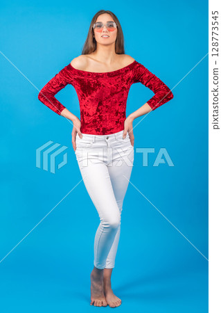 Beautiful woman with red blouse and white pants studio portrait 128773545