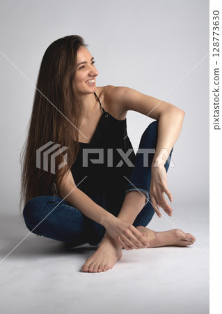 Studio portrait of beautiful longhair woman with jeans 128773630