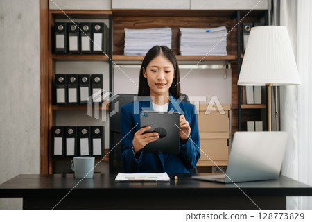Woman freelancer is working her job on computer tablet and laptop Doing accounting analysis report real estate investment data, Financial 128773829