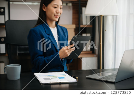 Woman freelancer is working her job on computer tablet and laptop Doing accounting analysis report real estate investment data, Financial 128773830