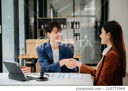 Asian business team and lawyers discussing contract papers sitting at the table. Concepts of law, advice, legal services. at office 128773964