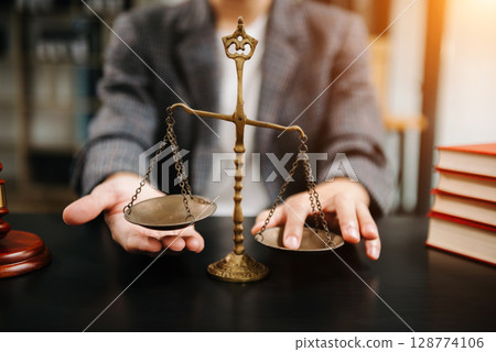 Male lawyer in the office with brass scale on wooden table. justice and law concept in morning light 128774106