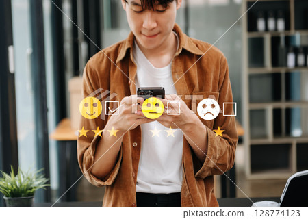 Customer service evaluation concept. Businesswoman pressing face smile emoticon show on virtual screen at tablet and smartphone in office Customer service evaluation concept. Businesswoman pressing face smile emoticon show on virtual screen at tablet and smartphone in office 128774123