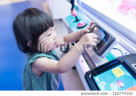 幼兒女孩在遊戲中心玩不明飛行物捕手 128774192