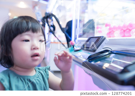 幼兒女孩在遊戲中心玩不明飛行物捕手 128774201