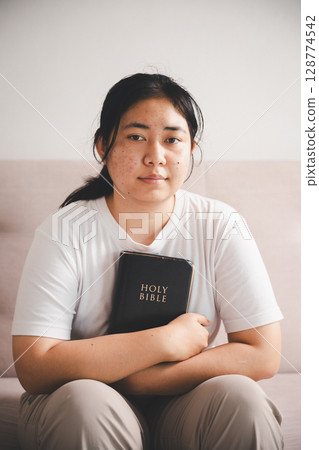 People and hope concept. Close up face female looking up feeling hope and faith. Woman praying. christianity faith, international day of prayer, female lost in thoughts feel lonely depressed pondering 128774542