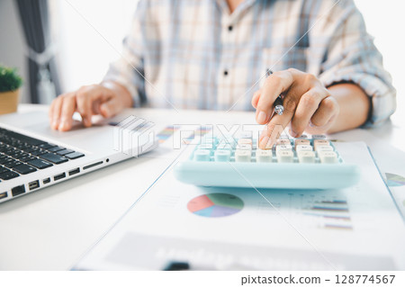 Accountant working on desk using calculator for calculate finance report in office. business finance, calculate tax by organizing financial documents, tracking income investment, accounting by hand. Accountant working on desk using calculator for calculate finance report in office. business finance, calculate tax by organizing financial documents, tracking income investment, accounting by hand. 128774567