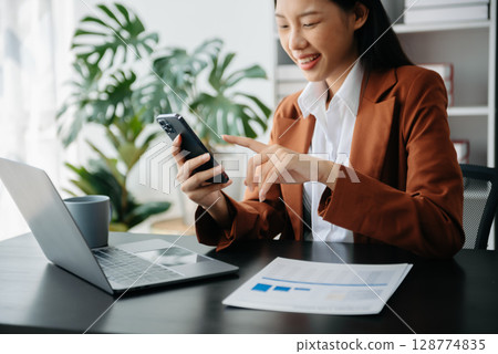 Businesswoman hand using laptop, tablet and smartphone in office. Digital marketing media mobile app and discussing plan new start up project. Finance task. Businesswoman hand using laptop, tablet and smartphone in office. Digital marketing media mobile app and discussing plan new start up project. Finance task. 128774835