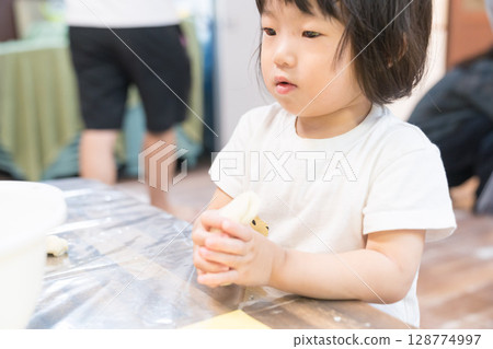 幼稚園裡玩紙黏土的小女孩 128774997