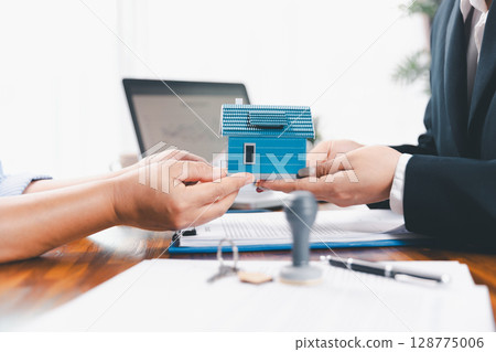 Bank approve loan to buy home concept. Real estate agent talked about terms of home purchase agreement, asked customer to sign documents to make contract legally. approved mortgage application form. 128775006