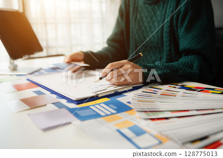 View of UI developer team brainstorming on their project with laptop, smartphone and digital tablet. Creative digital development agency. View of UI developer team brainstorming on their project with laptop, smartphone and digital tablet. Creative digital development agency. 128775013