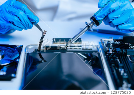 Electronics technician, electronic engineering electronic repair, electronics measuring and testing, repair and maintenance concepts.uses a voltage meter to check and upgrade 128775020