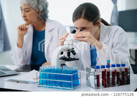 Scientist team meeting and writing analysis results in the laboratory study and analyze scientific sample Scientist team meeting and writing analysis results in the laboratory study and analyze scientific sample 128775126