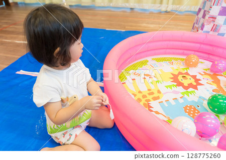 幼稚園裡玩水溜溜球釣魚的小女孩 128775260