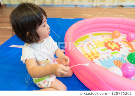 幼稚園裡玩水溜溜球釣魚的小女孩 128775261