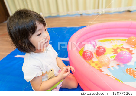 幼稚園裡玩水溜溜球釣魚的小女孩 128775263