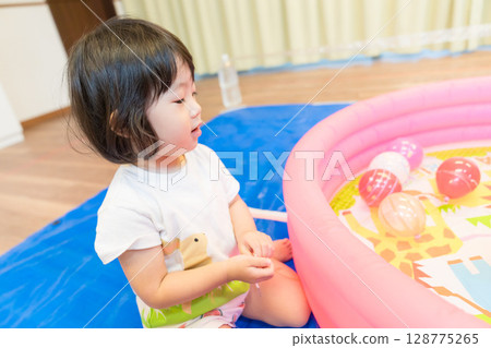 幼稚園裡玩水溜溜球釣魚的小女孩 128775265