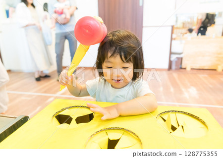 幼兒女孩在托兒所玩打地鼠遊戲 128775355
