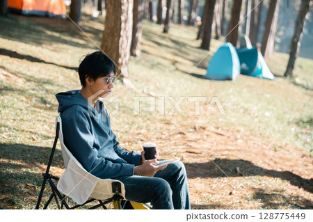 Remote work technology online close up communication smart phone laptop telephone digital travel brown nature sunlight camp beverage morning sit drink coffee tent orange outlying concept background. 128775449