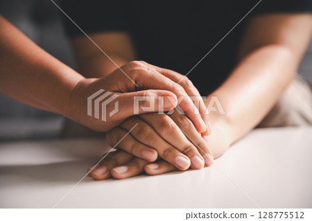 Hope and trust with crisis concept. Closeup, love and holding hands for support, comfort and care with grief, loss and empathy. people and family with compassion, sympathy and healing with bonding. 128775512