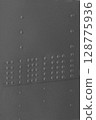 The surface of a metal wall with rivets close-up. 128775936