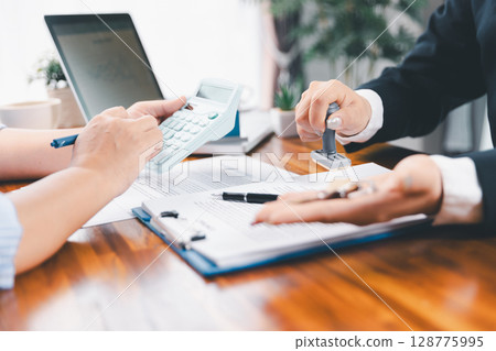 Bank approve loan to buy home concept. Real estate agent talked about terms of home purchase agreement, asked customer to sign documents to make contract legally. approved mortgage application form. 128775995