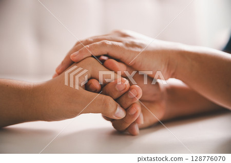 Hope and trust with crisis concept. Closeup, love and holding hands for support, comfort and care with grief, loss and empathy. people and family with compassion, sympathy and healing with bonding. Hope and trust with crisis concept. Closeup, love and holding hands for support, comfort and care with grief, loss and empathy. people and family with compassion, sympathy and healing with bonding. 128776070