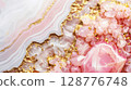 Close-up of a beautiful pink and gold geode crystal with stunning patterns, showcasing natural mineral beauty in a high-resolution image. 128776748