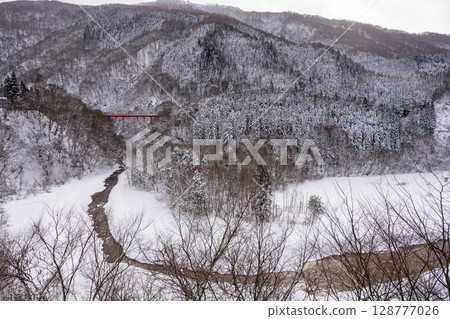 The red Takai Bridge stands out against the snowy scenery and the winter valley around Yamada Onsen (Nagano Prefecture) The red Takai Bridge stands out against the snowy scenery and the winter valley around Yamada Onsen (Nagano Prefecture) 128777026