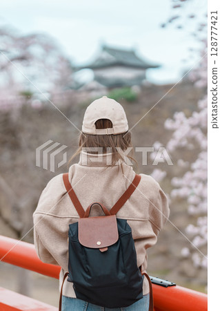 Woman tourist sightseeing Hirosaki Castle with Sakura Cherry Blossom in Spring, happy traveler travel in Hirosaki city, Aomori, Tohoku, Japan. Landmark famous in Japan. Travel and Vacation destination 128777421