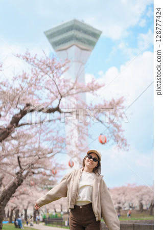 Woman tourist sightseeing Goryokaku Tower park with Sakura Cherry Blossom in Spring, happy traveler travel in Hakodate city, Hokkaido, Japan. famous Landmark, Japan Travel and Vacation destination 128777424