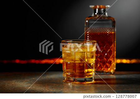 Whiskey with ice on a dark background. 128778007
