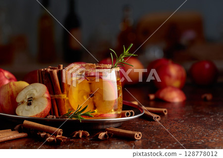 Apple cider with apple slices and a rosemary branch. 128778012