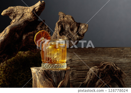 Old-fashioned cocktail with ice and dried orange slice. Old-fashioned cocktail with ice and dried orange slice. 128778024