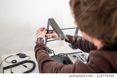 person adjusting ergonomic metal laptop stand on white desk in home office person adjusting ergonomic metal laptop stand on white desk in home office 128779300