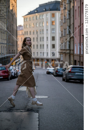 Young woman walking on Helsinki street in summer city evening Young woman walking on Helsinki street in summer city evening 128779379