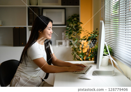 Teenage student studying or attending virtual class in a bright living space 128779406