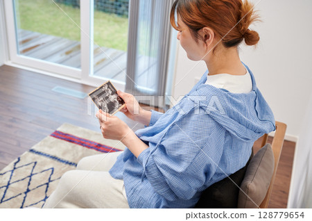 Pregnant woman, maternity, chair, heartwarming ultrasound photo 128779654