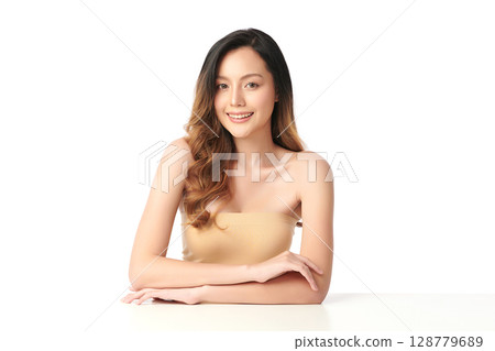 A beautiful young Asian woman with clean, fresh skin against a white background. Skincare, facial treatment, cosmetology, beauty, and spa. An elegant portrait of an Asian woman. 128779689