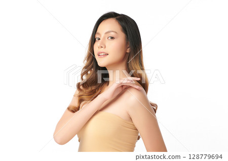 A beautiful young Asian woman with clean, fresh skin against a white background. Skincare, facial treatment, cosmetology, beauty, and spa. An elegant portrait of an Asian woman. 128779694