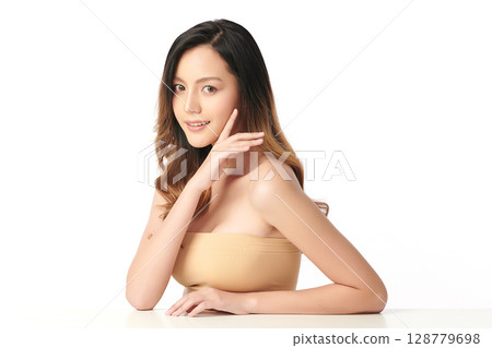A beautiful young Asian woman with clean, fresh skin against a white background. Skincare, facial treatment, cosmetology, beauty, and spa. An elegant portrait of an Asian woman. 128779698