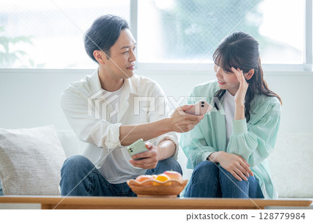 A couple complains about a secret on their smartphone 128779984