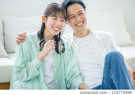 A young couple relaxing in the living room A young couple relaxing in the living room 128779996