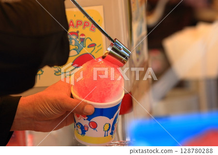 將糖漿加入刨冰中 將糖漿加入刨冰中 128780288