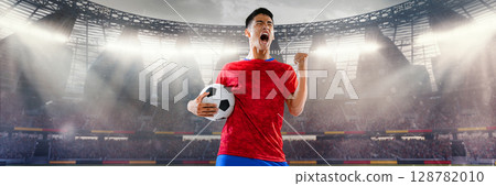 Football player in red shirt celebrating with ball in crowded 3D stadium 128782010