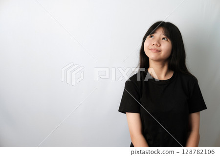 Cute Asian girl in black t-shirt, Looking Up and Slightly Smiling Cute Asian girl in black t-shirt, Looking Up and Slightly Smiling 128782106