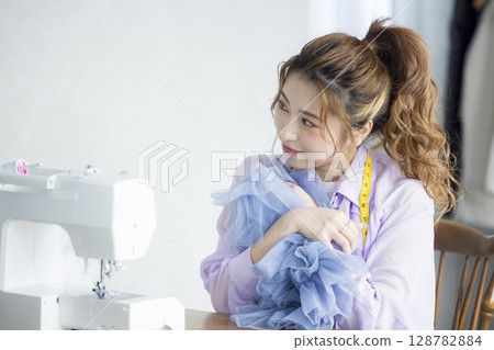 縫合與一台縫紉機的婦女 縫合與一台縫紉機的婦女 128782884