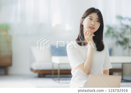 Young woman using a computer in the living room 128782916