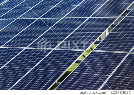 Extensive array of modern dark blue photovoltaic solar panels, efficiently capturing sunlight to generate clean, renewable electricity, fostering a sustainable future 128783025