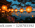 a traditional Obon dance performed at night, participants wearing yukatas dancing in a circle under glowing lanterns, a serene evening sky enhancing the scene 128783392